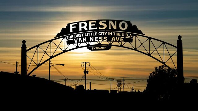 The iconic Fresno "Best Little City in the USA" Van Ness Avenue gate, silhouetted against a warm sunset
